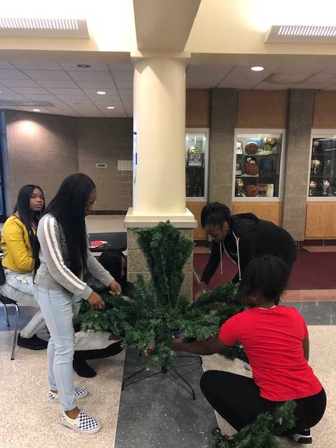 Cheerleaders setting up holiday trees