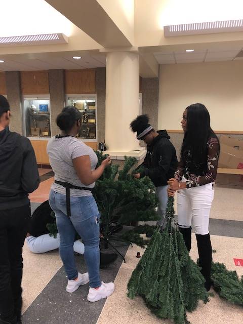 Cheerleaders setting up holiday trees