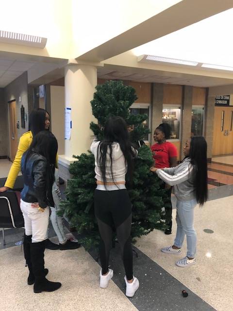 Cheerleaders setting up holiday trees