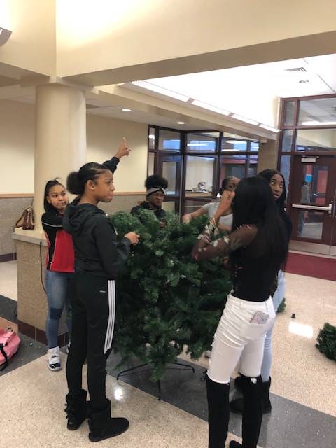 Cheerleaders setting up holiday trees