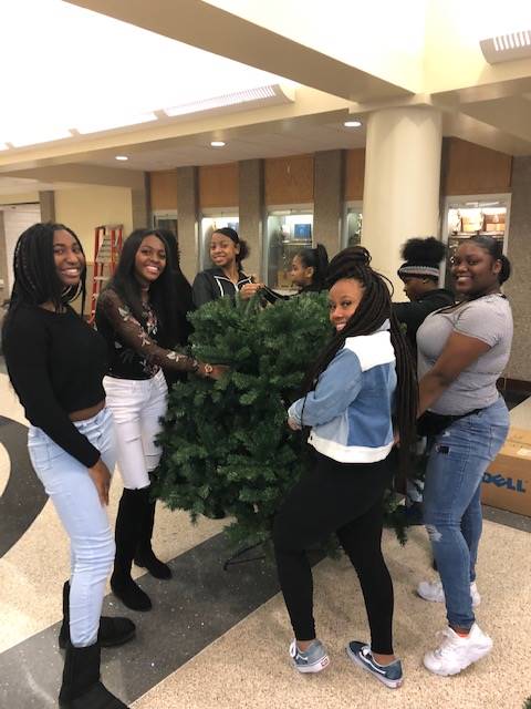 Cheerleaders setting up holiday trees