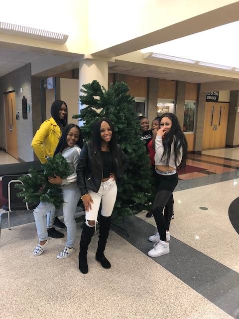 Cheerleaders setting up holiday trees