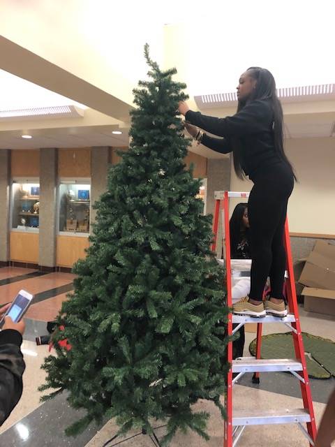 Cheerleaders setting up holiday trees