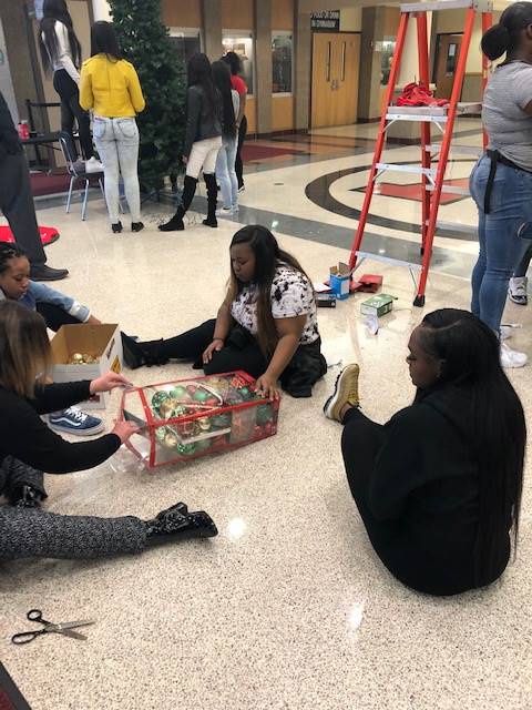 Cheerleaders setting up holiday trees