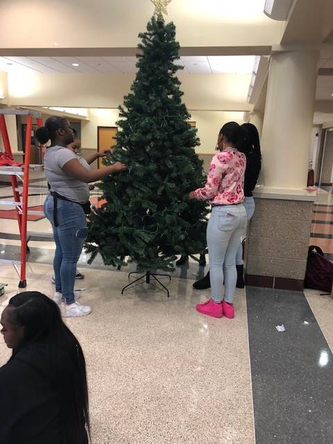 Cheerleaders setting up holiday trees