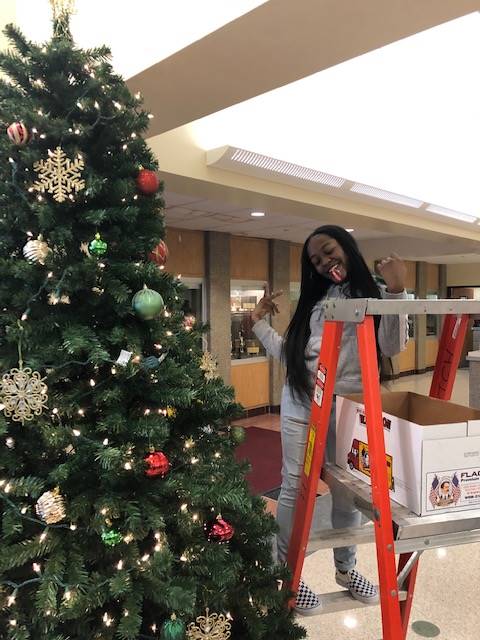 Cheerleaders setting up holiday trees