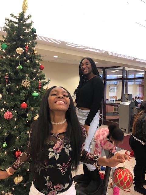 Cheerleaders setting up holiday trees