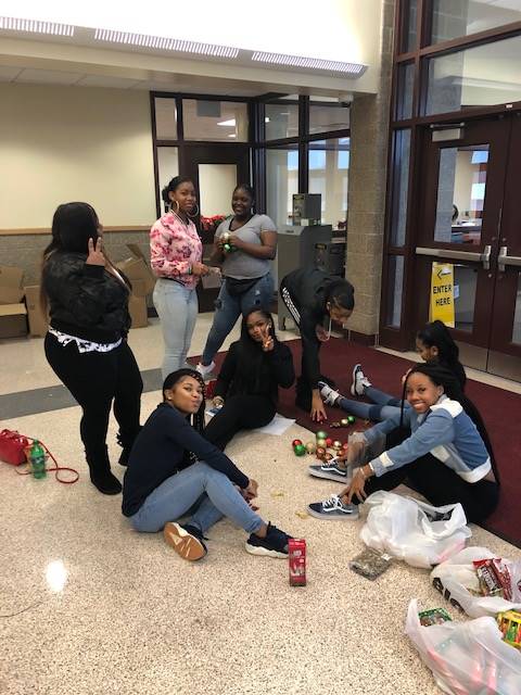 Cheerleaders setting up holiday trees