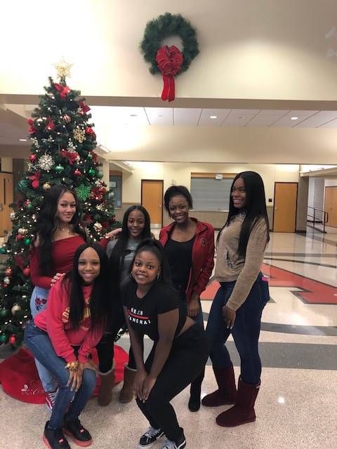 Cheerleaders setting up holiday trees