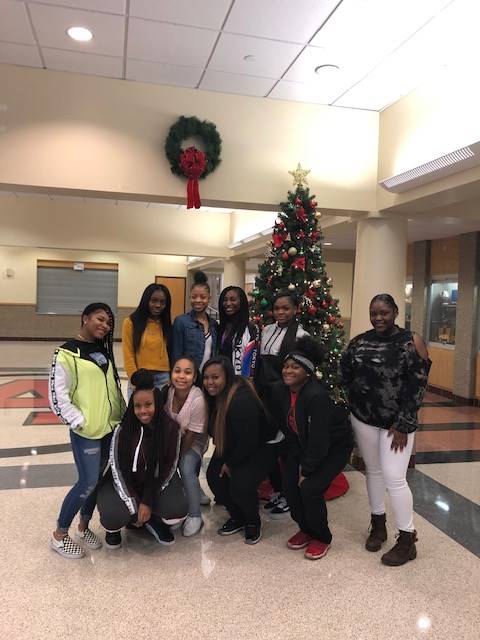 Cheerleaders setting up holiday trees