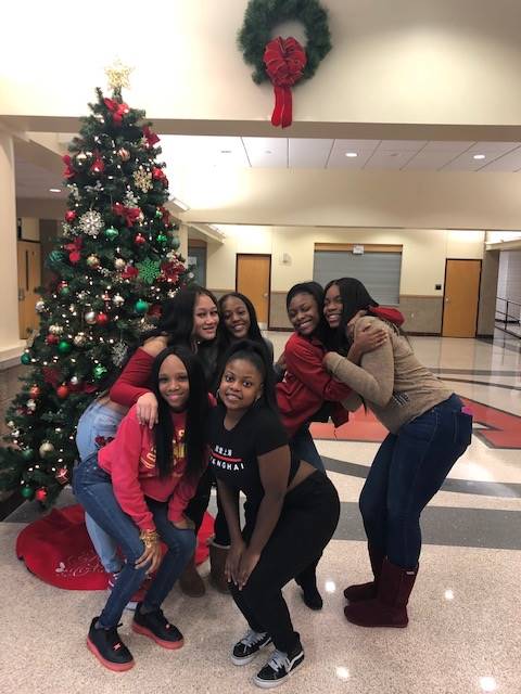 Cheerleaders setting up holiday trees