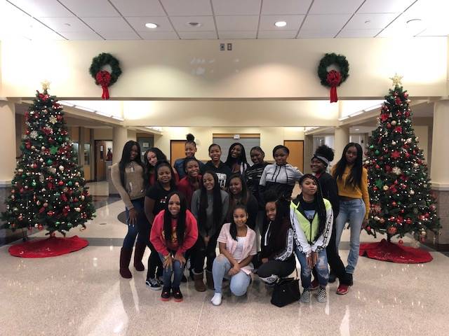 Cheerleaders setting up holiday trees